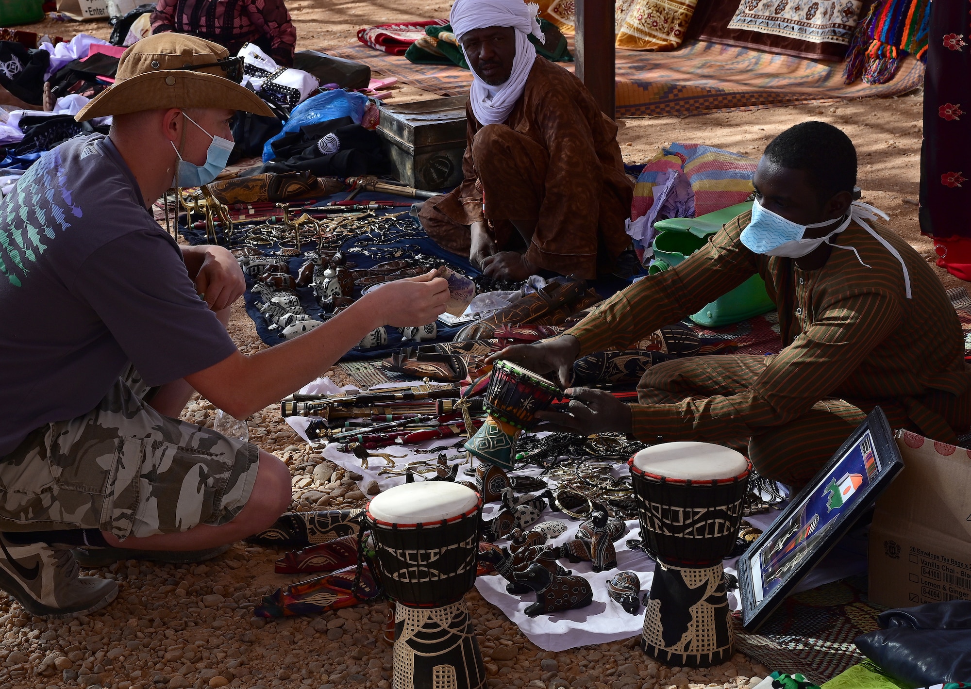A U.S. Service member purchases a drum during a bazaar at Nigerien Air Base 201, Agadez, Niger Feb. 27, 2022. U.S. service members purchased approximately 10,532,000 West African CFA francs ($18K USD) worth of goods during the bazaar. Events like these enhance U.S., Niger relationships and stimulate local economic development. (U.S. Air Force photo by Tech. Sgt. Stephanie Longoria)