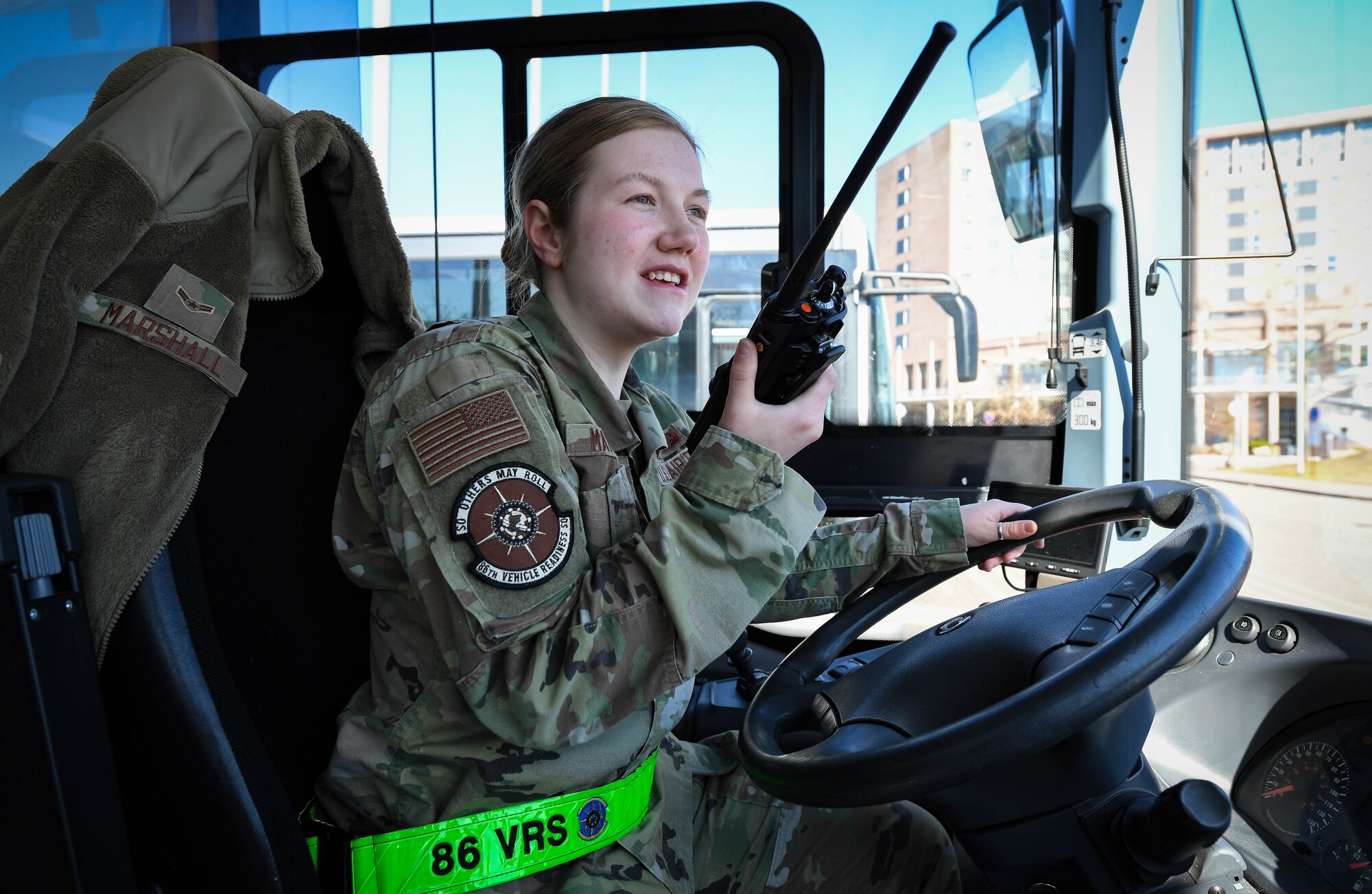 U.S. Air Force Airman 1st Class Mckayla Marshall, 86th Vehicle Readiness Squadron vehicle operator, calls dispatch at Ramstein Air Base, Germany, March 8, 2022. With an increased surge of incoming service members sent to support Ramstein operations, ground transportation Airmen are accommodating newcomers with transportation services by means of a shuttle bus. A QR code is available at on-base bus stops to provide bus stop times. (U.S. Air Force photo by Airman 1st Class Jared Lovett)