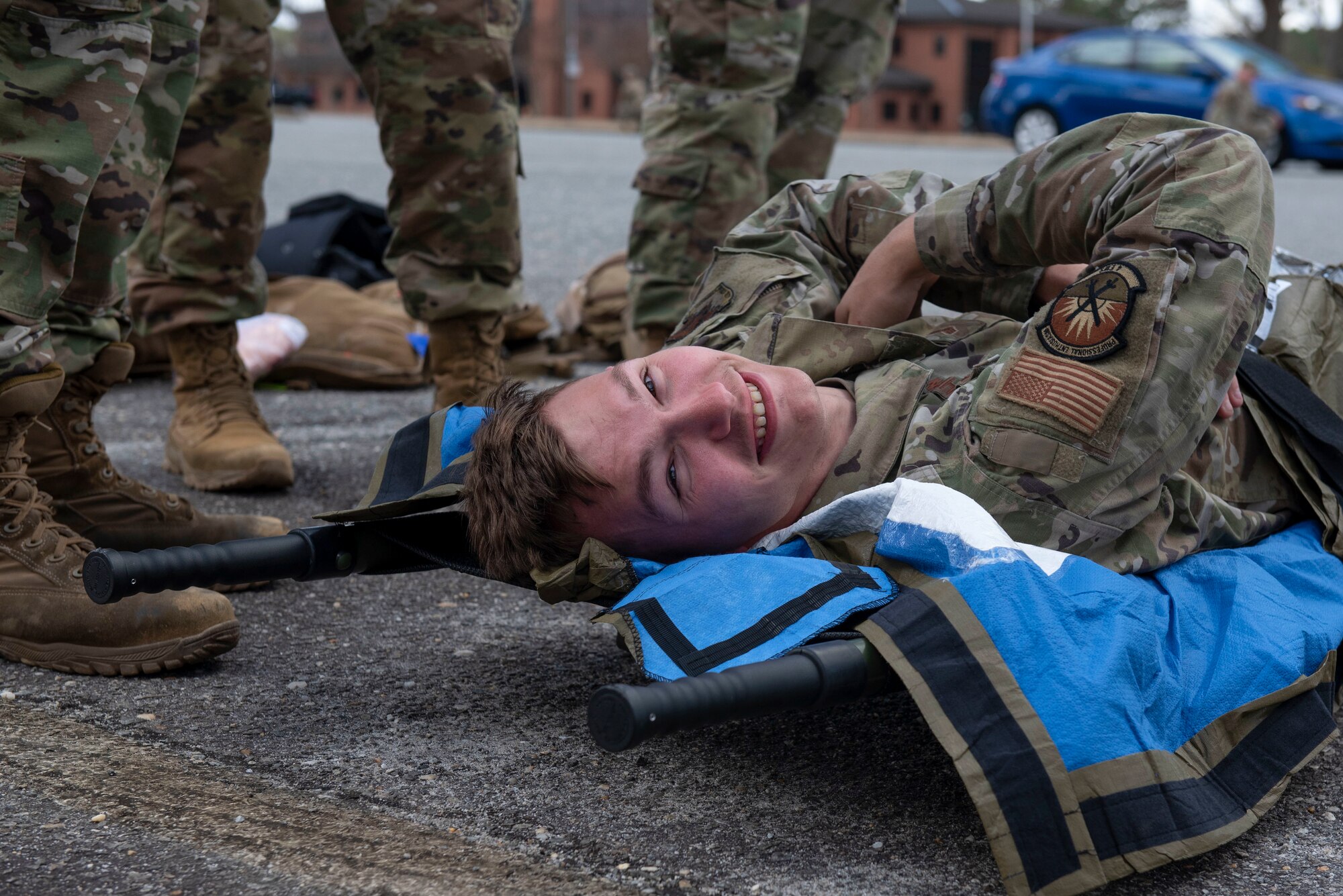 Senior Airman Matthews, 4th Equipment Maintenance Squadron repair and reclamation journeyman, simulates being injured during tactical casualty combat care training at Seymour Johnson Air Force Base, Feb. 18, 2022. TCCC training prepares for real-world scenarios. (U.S. Air Force photo by Airman 1st Class Sabrina Fuller)