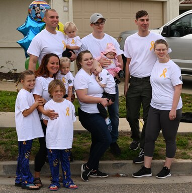 The Cates family and neighbors gather together to pose for a photo Jan. 29, 2022, at Vandenberg Space Force Base, Calif.  The family and their neighbors posed for photos towards the end of a parade that celebrated their son, Grayson, coming home from seven months of treatment for brain cancer. (U.S. Space Force photo by Airman 1st Class Tiarra Sibley)