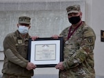 Walter Reed National Military Medical Center's Director Army Brig. Gen. Jack Davis, left, presents an Order of Military Medical Merit certificate to Army Sgt. 1st Class Nathan Tormala outside of WRNMMC, March 10, 2022