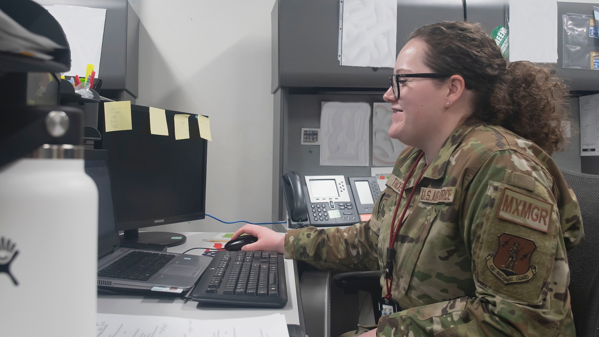 Airman 1st Class Marquise Thacker, a 131st Maintenance Operations Flight maintenance management production apprentice, checks email at her workstation on Whiteman Air Force Base, Missouri. Thacker recently returned from a 34-day deployment to New Jersey supporting Operation Allies Welcome. Note: some portions of this image are blurred for security purposes. (U.S. Air National Guard photo illustration by Staff Sgt. Joshua Colligan)