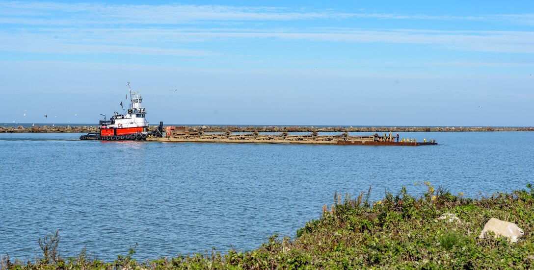 A tug boat pushes a barge in Cleveland Harbor.