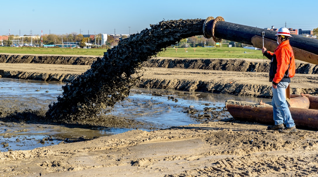 A hydraulic pump pushes dredged material into a confined disposal facility.