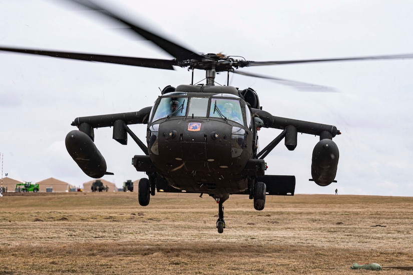 A helicopter lands in a field.