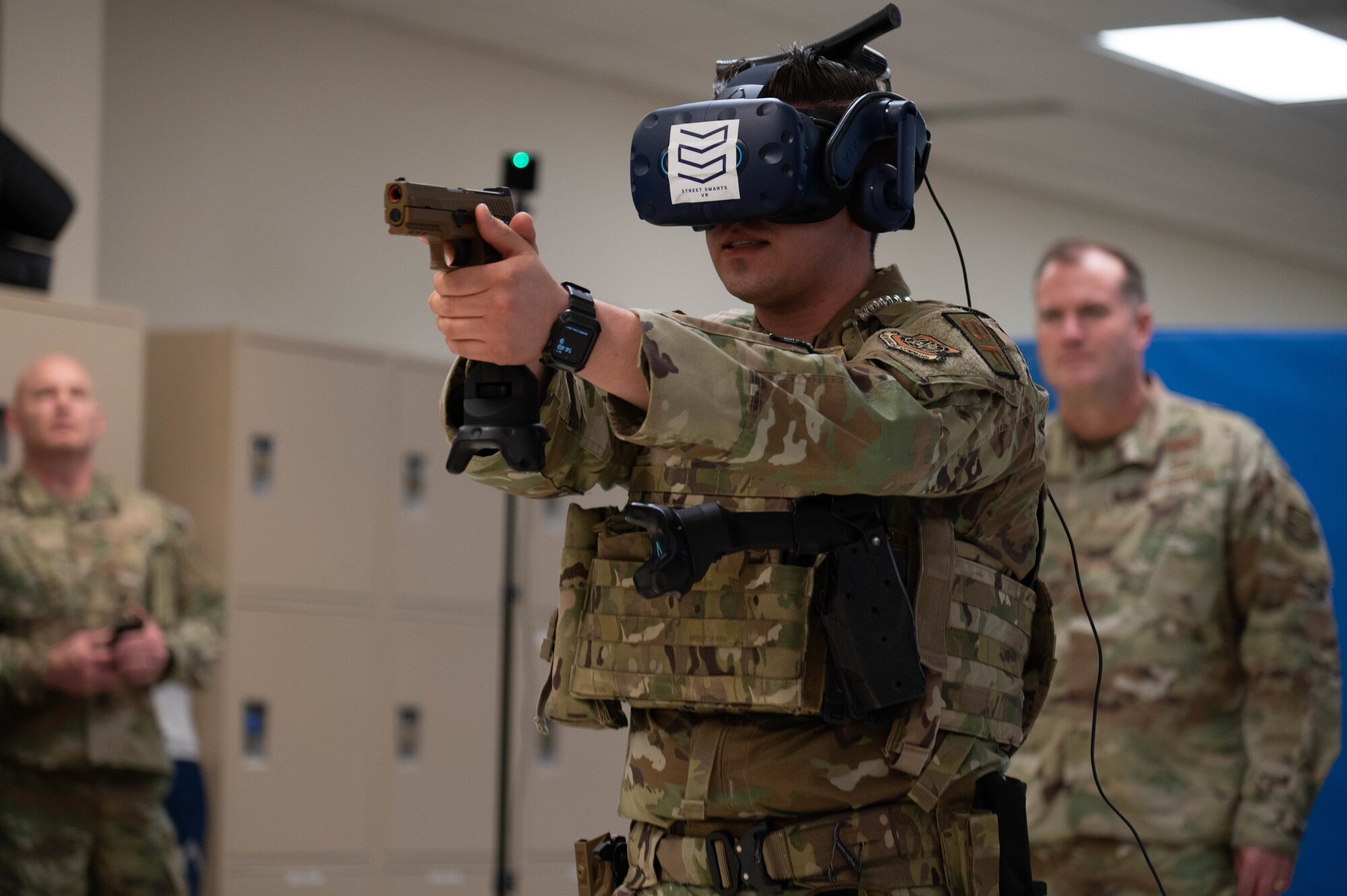 U.S. Air Force Senior Airman Kyle Ramirez, 375th Security Forces Squadron instructor, demonstrates Virtual Reality training equipment for high stress scenarios to Maj. Gen. Kenneth T. Bibb, 18th Air Force commander, and Chief Master Sgt. Chad Bickley, 18th Air Force command chief, trains for an aggressive situation using a virtual headset during a tour at Scott Air Force Base, Illinois, March 9, 2022. This device is utilized for training purposes in the 375th Security Forces Squadron to increase defender’s efficiency in responding. (U.S. Air Force photo by Airman 1st Class Mark Sulaica)
