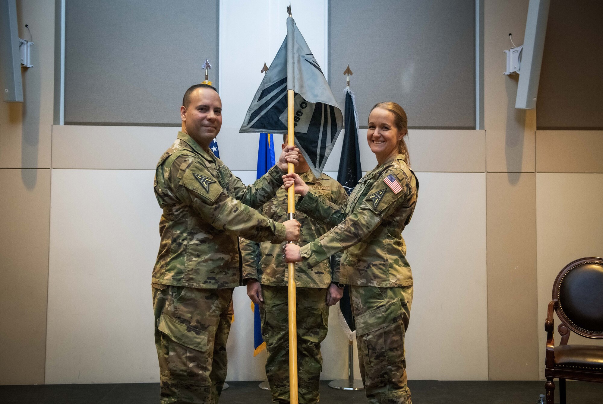 U.S. Space Force Col. Miguel Cruz (left), the Space Delta 4 commander, is given the 460th Operations Support Squadron’s guidon from Lt. Col. Carrie Zederkof (right), the DEL 4 S-Staff director, during the inactivation of the 460th OSS ceremony March 11, 2022, at the Leadership Development Center on Buckley Space Force Base, Colo.