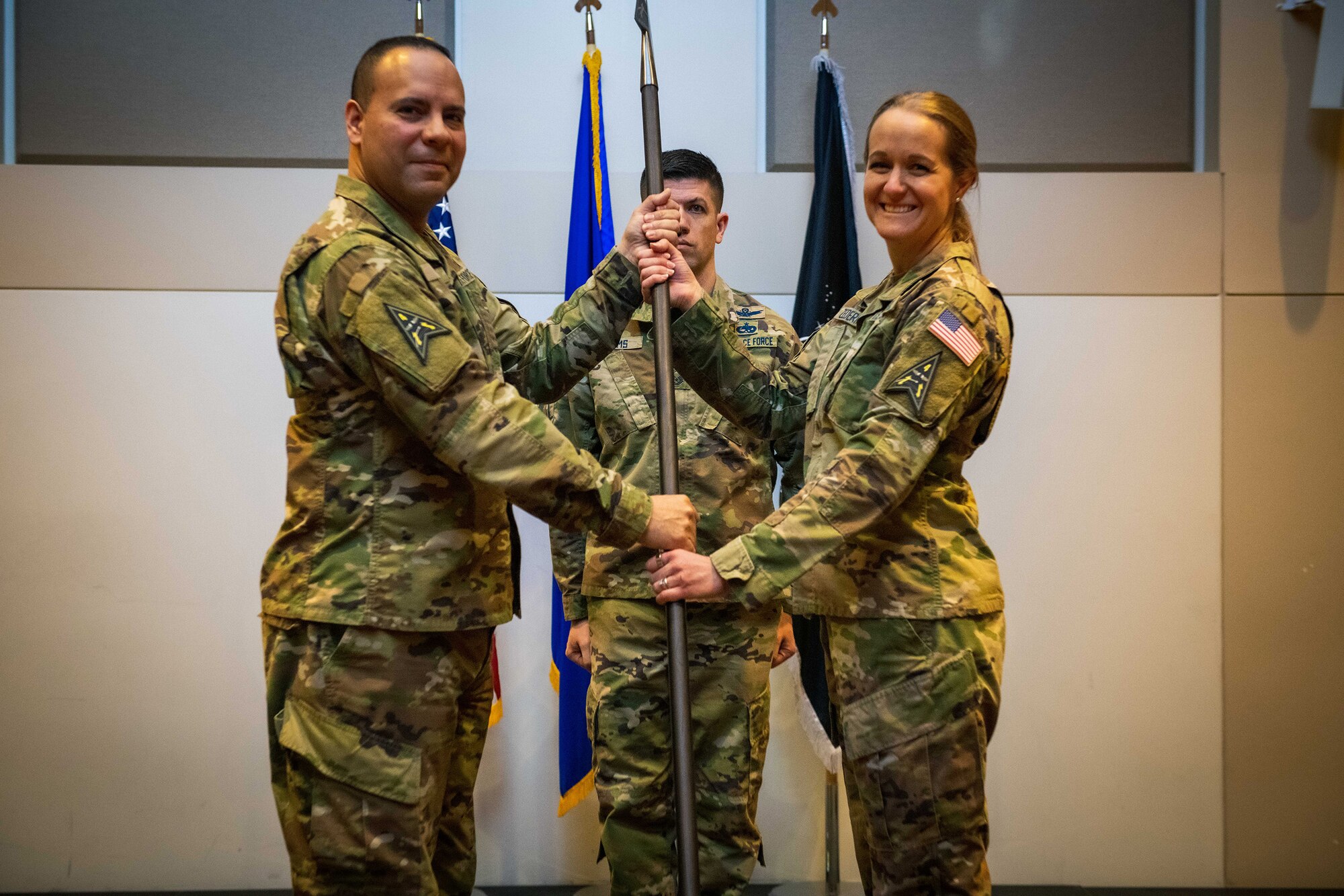 U.S. Space Force Col. Miguel Cruz (left), the Space Delta 4 commander, gives the DEL 4 spear to Lt. Col. Carrie Zederkof (right), the DEL 4 S-Staff director, to signal the activation of the DEL 4 S-Staff during the inactivation of the 460th Operations Support Squadron ceremony March 11, 2022, at the Leadership Development Center on Buckley Space Force Base, Colo.