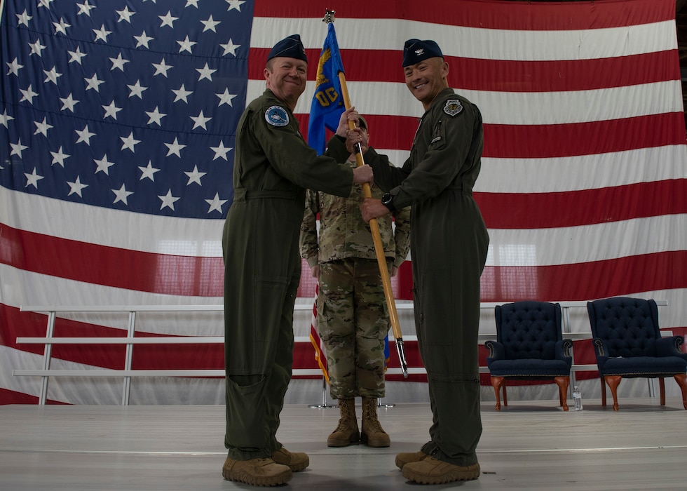 An Airman passes the ceremonial guidon to another Airman.