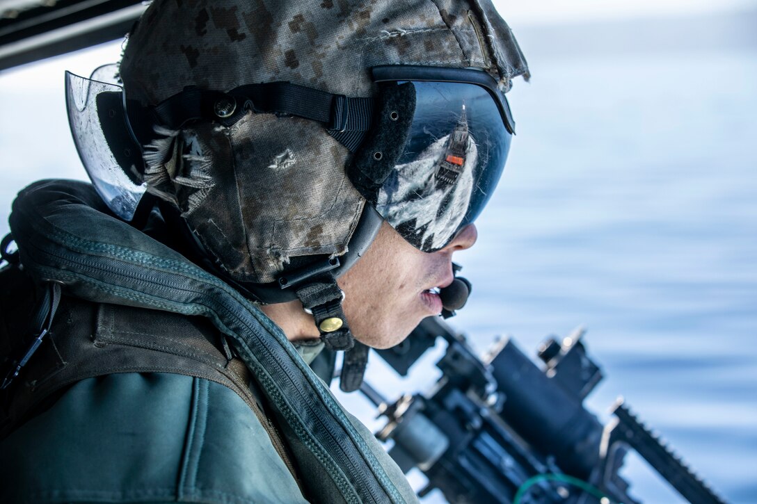 U.S. Marine Corps Sgt. William Ton, a crew chief assigned to Marine Attack Light Attack Helicopter Squadron 469, Marine Aircraft Group 39, 3rd Marine Aircraft Wing (MAW), notifies the pilots of their distance from a Range Support Craft during a Helicopter Visit, Board, Search, and Seizure training exercise on a UH-1Y Venom off the coast of San Clemente Island, California, Feb. 17, 2022. Winter Fury 22 provides the Marines of 3rd MAW with realistic, relevant training opportunities necessary to respond to any crisis across the globe and win decisively in a highly contested, maritime conflict. (U.S. Marine Corps photo by Sgt. Samuel Ruiz)