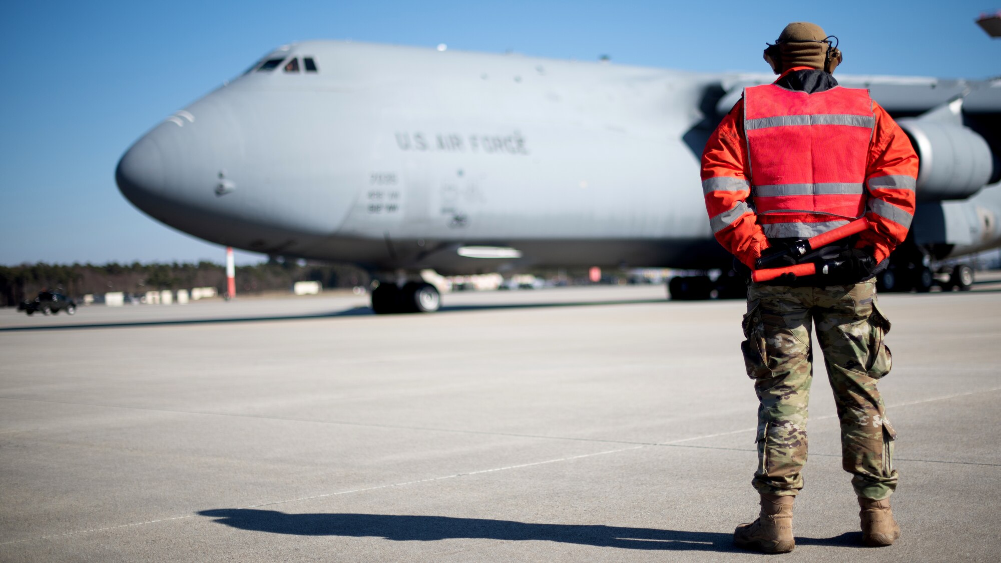 U.S. Air Force Senior Airman Dakota Woods, 726th Air Mobility Squadron aircraft electrical and environmental systems journeyman, prepares to marshal a U.S. Air Force C-5M Super Galaxy aircraft at Spangdahlem Air Base, Germany, Mar. 7, 2022.
