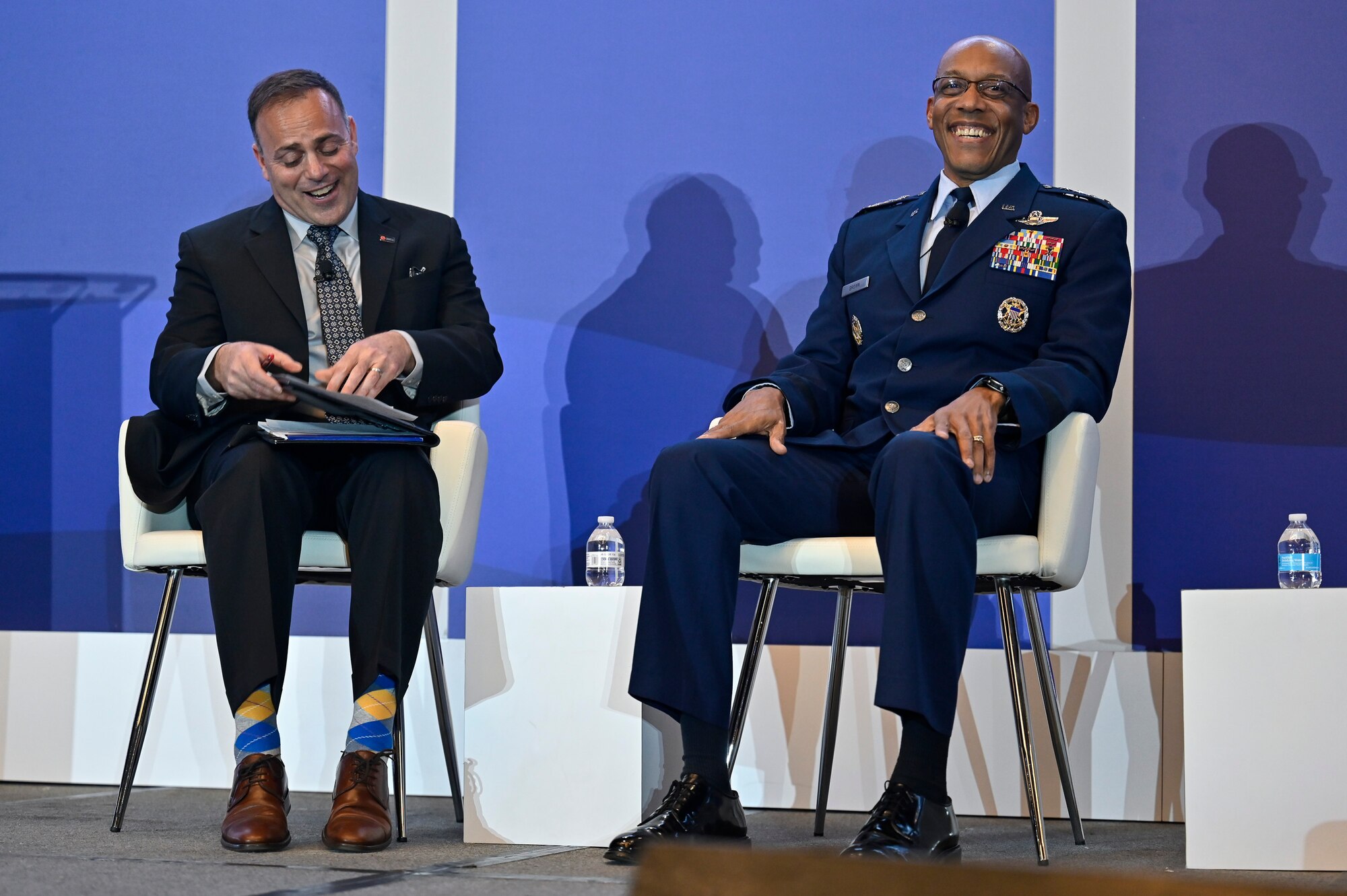 Air Force Chief of Staff Gen. CQ Brown, Jr. laughs with moderator Sal Nodjomian during a discussion for the 2022 Association of Defense Communities National Summit in Arlington, Va., March 8, 2022. Brown spoke about priorities and challenges for the Air Force and the importance of communities. (U.S. Air Force photo by Eric Dietrich)