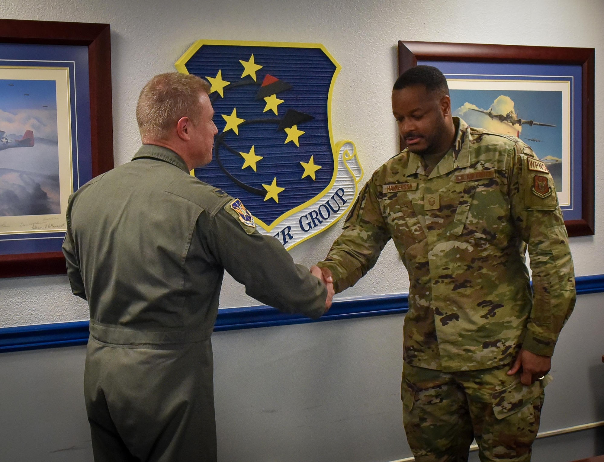 (left) 301st Fighter Wing Commander Col. Allen Duckworth gives his commander's coin to recognize Master Sgt. Rodney Hankerson, 44th Fighter Group Weapons Section chief during the wing's visit to the 44 FG at Eglin Air Force Base, Fla., March 4. Hankerson, who also works in the same position as a civilian, recently won the Gen. Leo Marquez Award at the AFRC level for Aircraft Maintenance Civilian Technician category. This award recognizes base-level civil service aircraft, munitions and missile maintenance personnel who perform hands-on maintenance or manage a maintenance function. (U.S. Air Force photo by Master Sgt. Jeremy Roman)