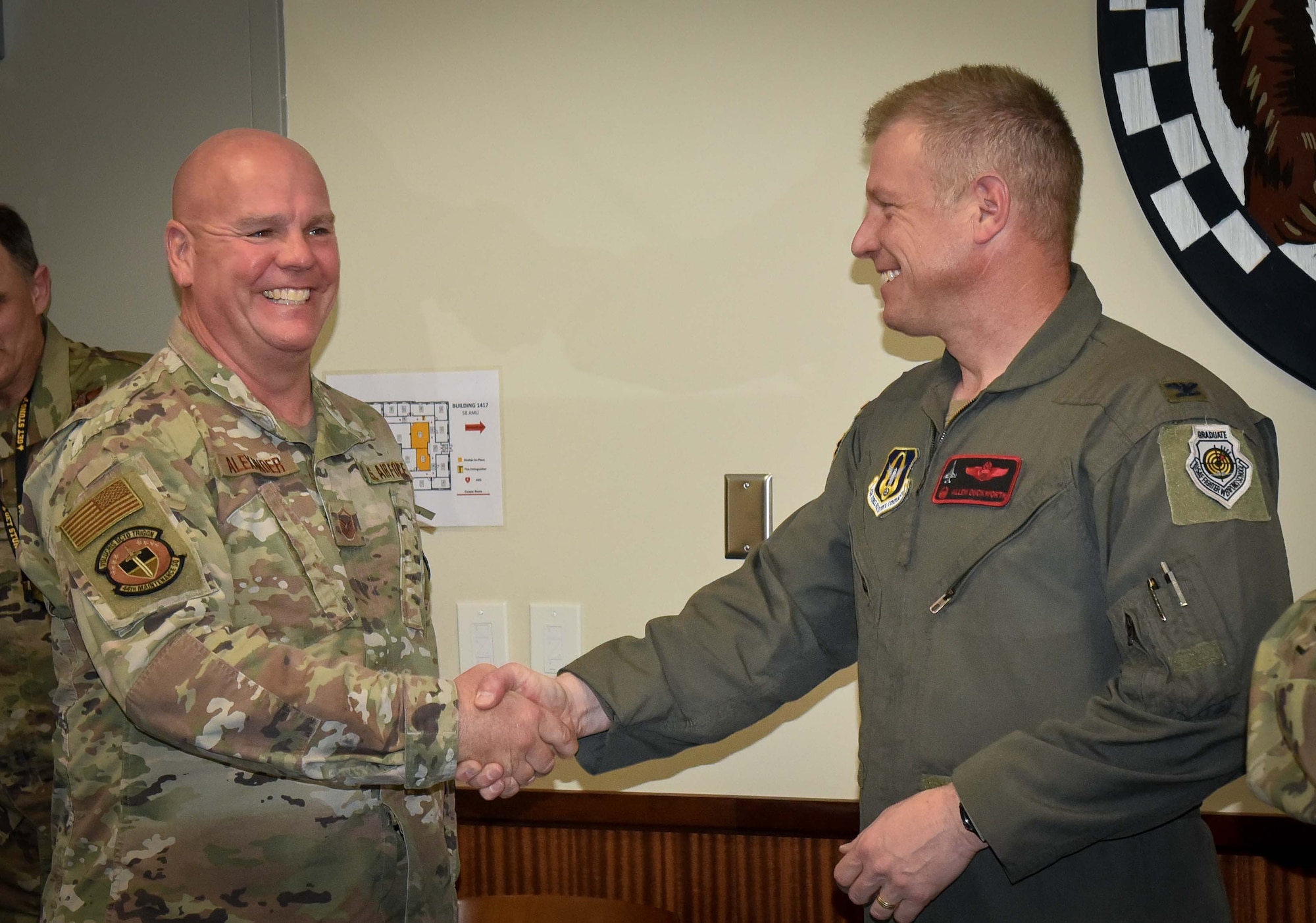 (right) 301st Fighter Wing Commander Col. Allen Duckworth gives his commander's coin to recognize Master Sgt. Gregory Alexander, 44th Fighter Group Aerospace Ground Equipment flight chief during the wing's visit to the 44 FG at Eglin Air Force Base, Fla., March 4. Alexander's willingness to go the extra mile and expertise in both the F-22 and F-35 airframes allowed him to ensure consistent mission operations and serve as a 44 FG anchor. (U.S. Air Force photo by Master Sgt. Jeremy Roman)
