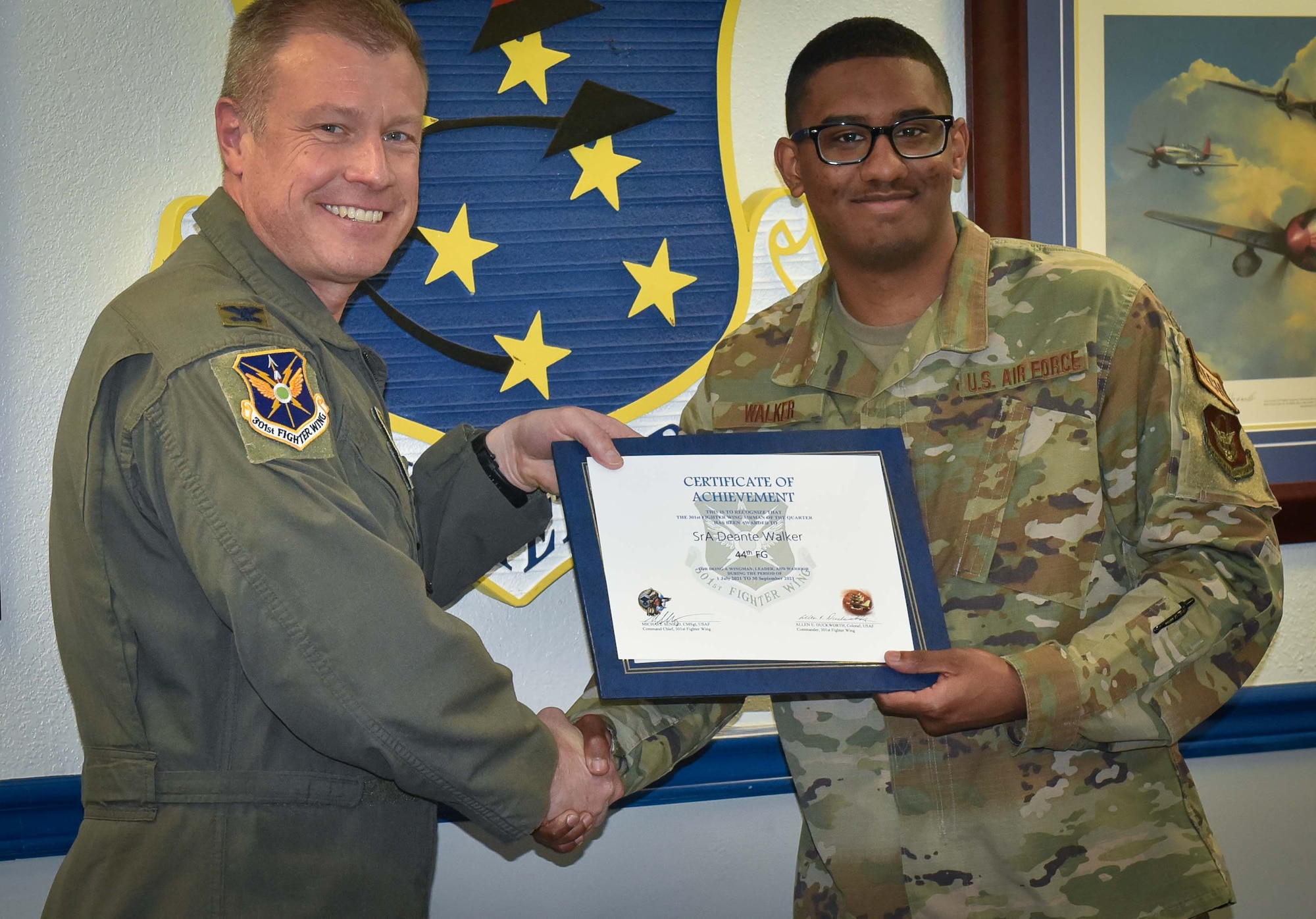 (left) 301st Fighter Wing Commander Col. Allen Duckworth recognizes Senior Airman Deante Walker, 44th Fighter Group Maintenance Squadron F-22 Journeyman during the wing's visit to the 44 FG at Eglin Air Force Base, Fla., March 4. For Walker's dedication and impact, he was selected as the 44 FG and 44 FG MXS Airman of the Year for 2021 as well as being selected as the Airman of the quarter for 3rd quarter 2021. (U.S. Air Force photo by Master Sgt. Jeremy Roman)