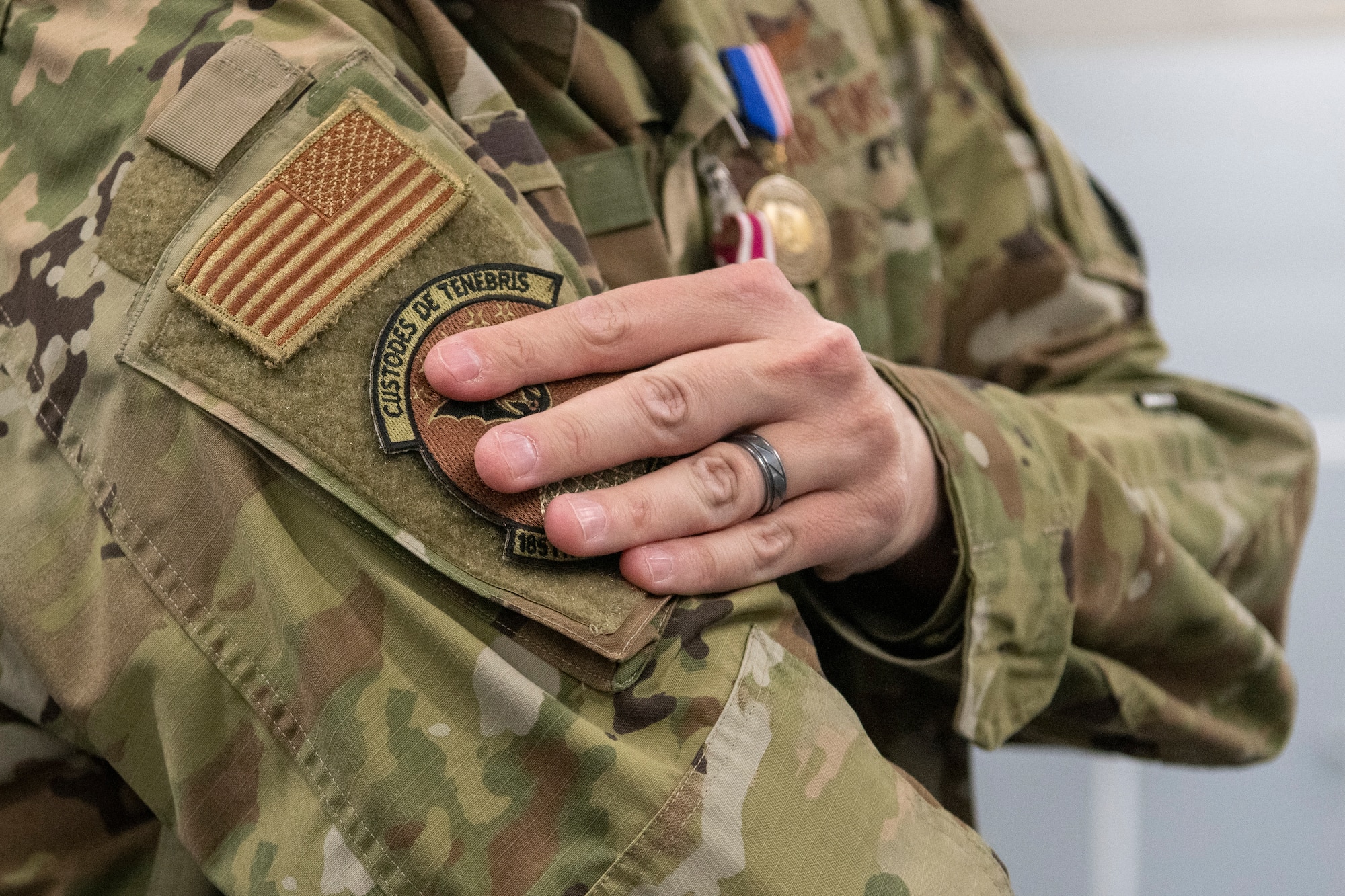 An Airman places the 185th Cyberspace Operations Squadron bat patch onto their sleeve.