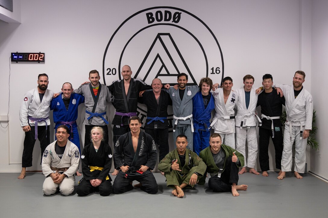 U.S. Marines and Norwegian civilians pose for a group photo after a community outreach program that allows U.S. Marines and Norweigian civilians to learn Jiu-Jitsu techniques during Exercise Cold Response '22 at Bodø, Norway, March 3, 2022. Exercise Cold Response ’22 is a biennial exercise that takes place across Norway, with participation from each of its military services, as well as from 26 additional North Atlantic Treaty Organization (NATO) allied nations and regional partners. (U.S. Marine Corps photo by Lance Cpl. Kyle Jia)