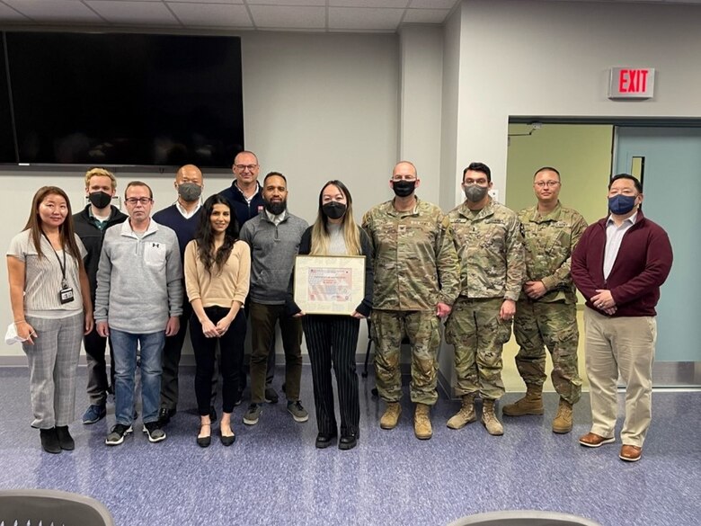 Kayla Toy (center), Far East District intern, stands with the Far East District team during her farewell luncheon at the headquarters building, March 7. Toy’s internship is set to complete October 2022. She will then advance to a permanent position in the Corps. (Courtesy photo)
