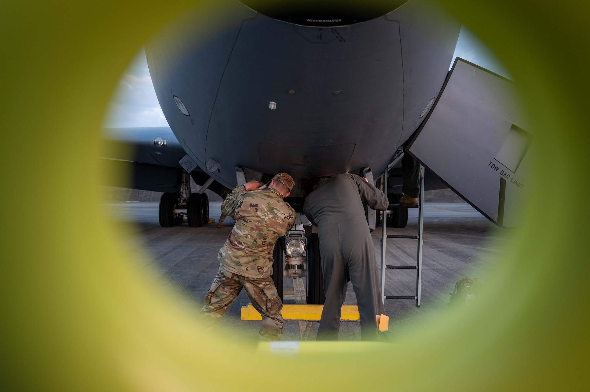 Two Airmen conduct preflight checks on an aircraft