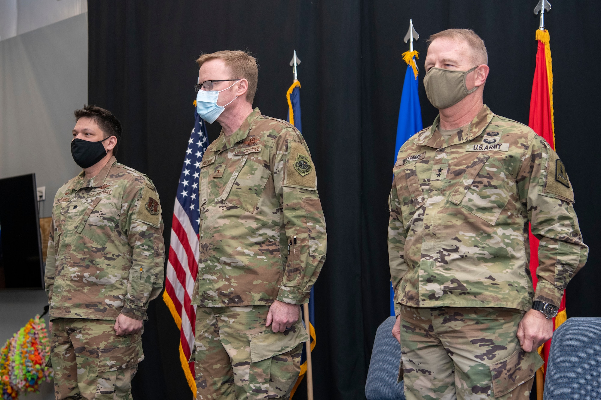 From right, Maj. Gen. Timothy P. Williams, the Adjutant General of Virginia, Brig. Gen. Bryan E. Salmon, the Assistant Adjutant General for Air National Guard Strategic Initiatives, and Lt. Col. Jonathan Esparza, 185th Cyberspace Operations Squadron commander, stand at attention on a stage during an end of mobilization ceremony Feb. 25, 2022, in Hampton, Virginia.