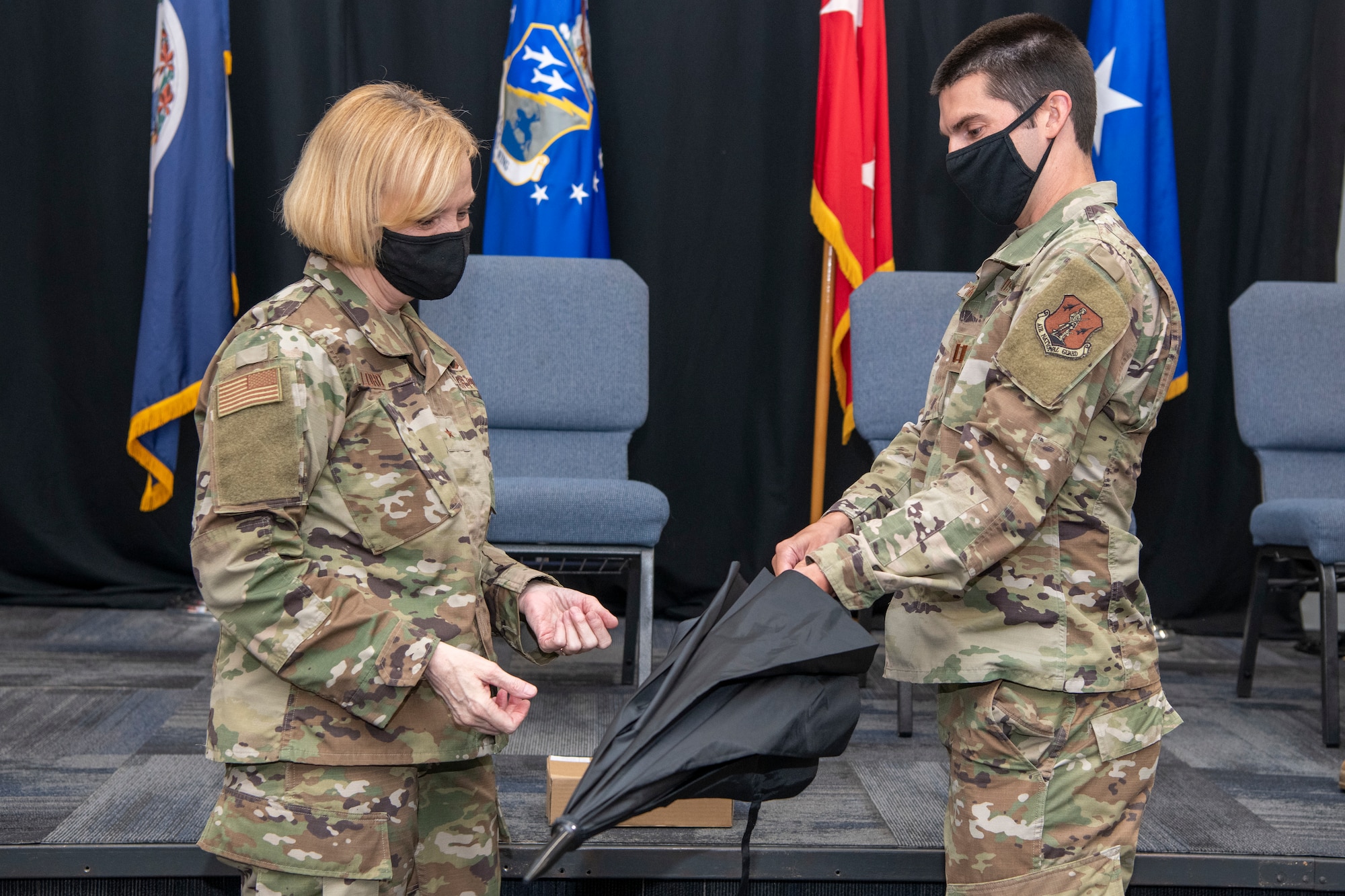 Brig. Gen. Toni M. Lord, Virginia National Guard air component commander, is gifted an umbrella signed by members of the 185th Cyberspace Operations Squadron prior to an end of mobilization ceremony Feb. 25, 2022, in Hampton, Virginia.