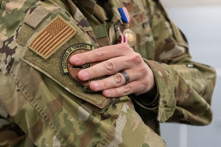 An Airman places the 185th Cyberspace Operations Squadron bat patch onto their sleeve.