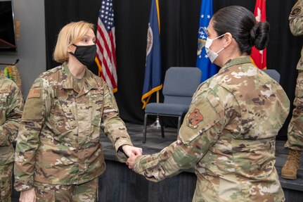 Brig. Gen. Toni M. Lord, Virginia National Guard air component commander, presents her challenge coin to members of the 856th Cyber Protection Team prior to an end of mobilization ceremony Feb. 25, 2022, in Hampton, Virginia.