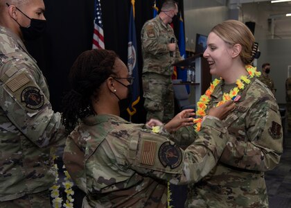 An Airmen is presented with a lei at an end of mobilization ceremony Feb. 25, 2022, in Hampton, Virginia.