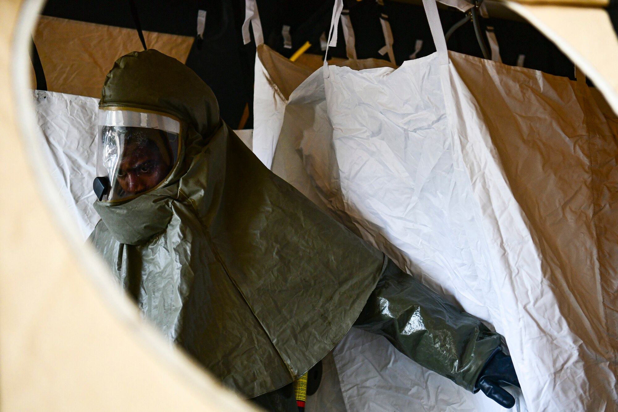 An Airman observes a decon shelter assemble.