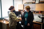 Dr. Patricia Lillquist, right, receives a Commander’s Coin in recognition of her excellence in patient care from Navy Captain Elizabeth Adriano on Monday, March 7, 2022.   Lillquist serves in the Behavioral Health unit aboard Naval Health Clinic Cherry Point.