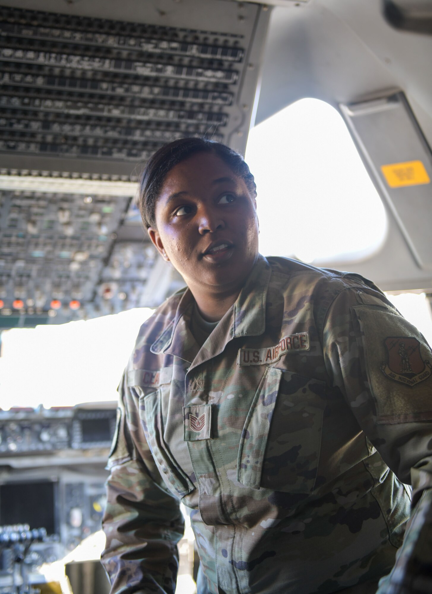 Tech. Sgt. Asia Clay, an aircrew flight equipment technician with the 172nd Operations Support Squadron, Jackson, Mississippi, explains features found in the cockpit of a C-17 Globemaster III, Feb 15, 2022.