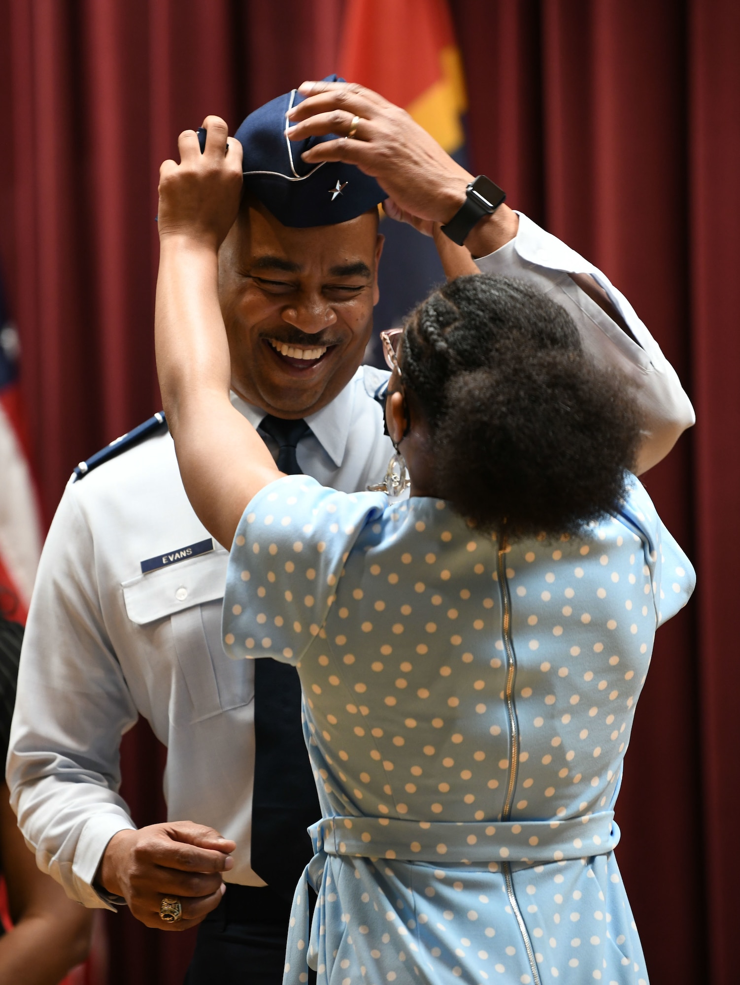 Brig. Gen. Edward H. Evans, Jr., chief of staff, Mississippi Air National Guard, and the first Mississippi Air National Guard member to be promoted to the rank of brigadier general, receives his cover from his daughter during his promotion ceremony at Mississippi National Guard Joint Force Headquarters, Jackson, Mississippi, March 5, 2022.