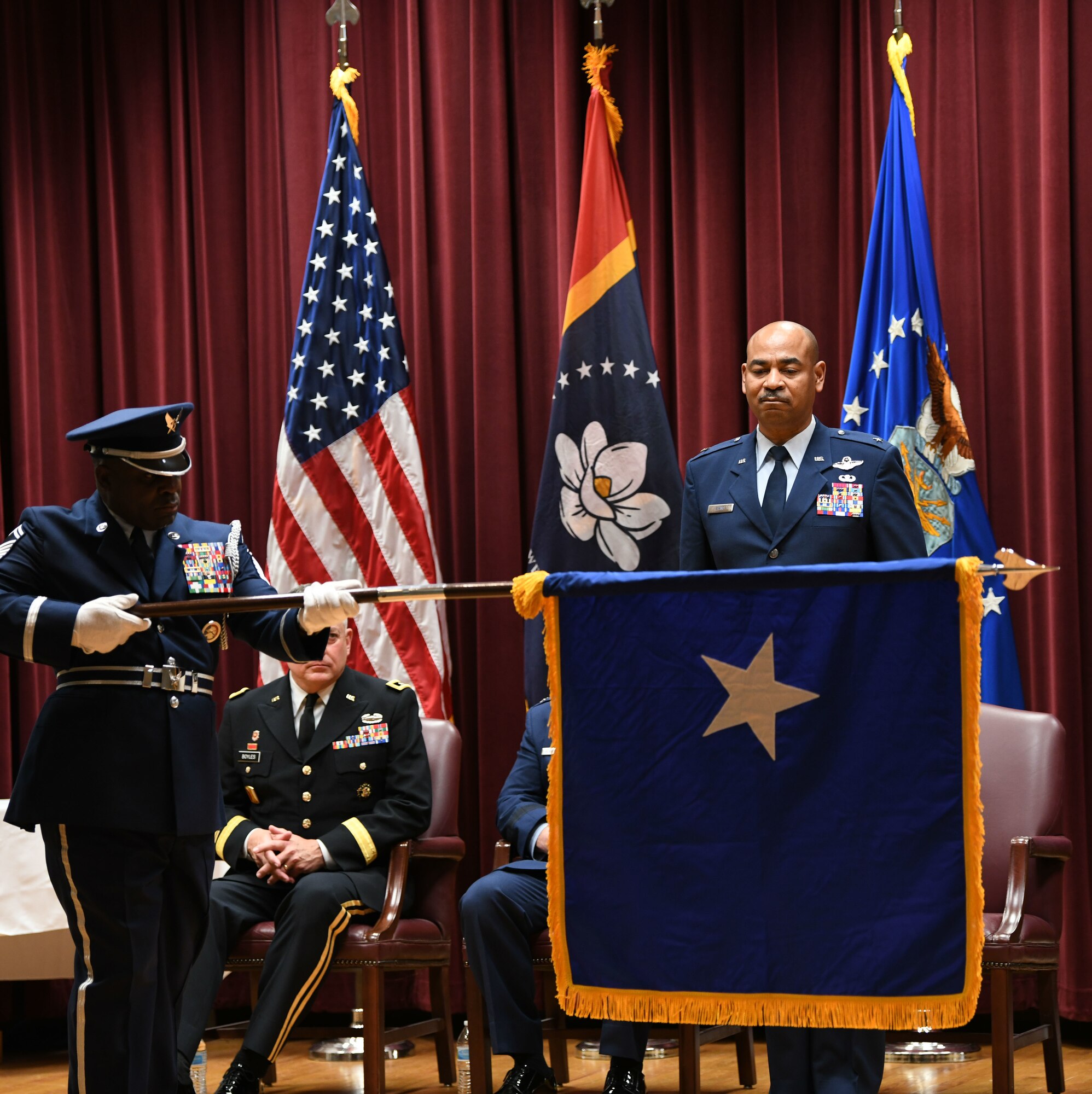 Brig. Gen. Edward H. Evans, Jr., chief of staff, Mississippi Air National Guard, and the first Mississippi Air National Guard member to be promoted to the rank of brigadier general, is presented with his personal flag during his promotion ceremony at Mississippi National Guard Joint Force Headquarters, Jackson, Mississippi, March 5, 2022.