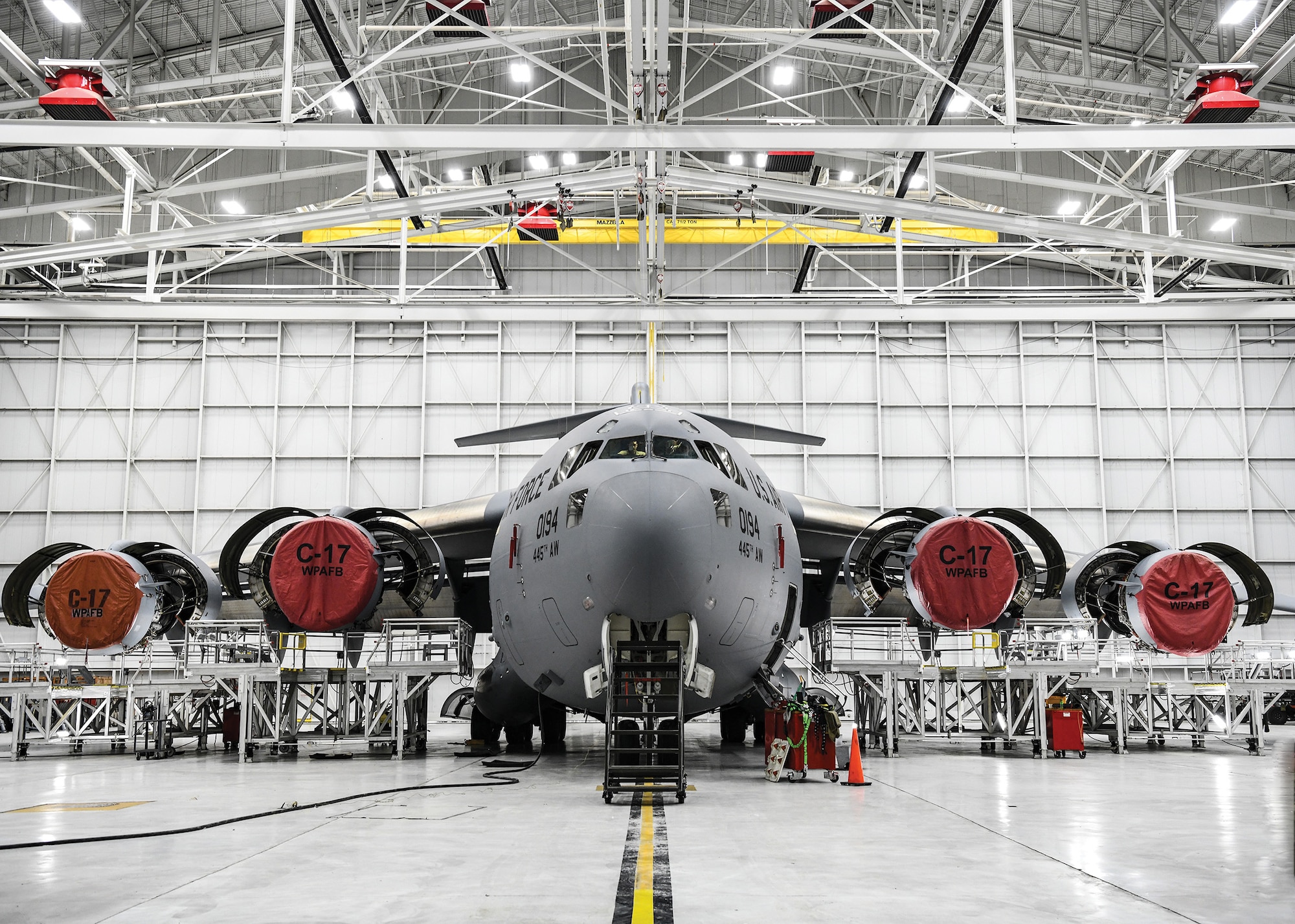 A 445th Airlift Wing C-17 Globemaster III sits in a hangar as Airmen from the 445th Maintenance and Aircraft Maintenance Squadrons prepare to perform a Home station check Feb. 18, 2022.