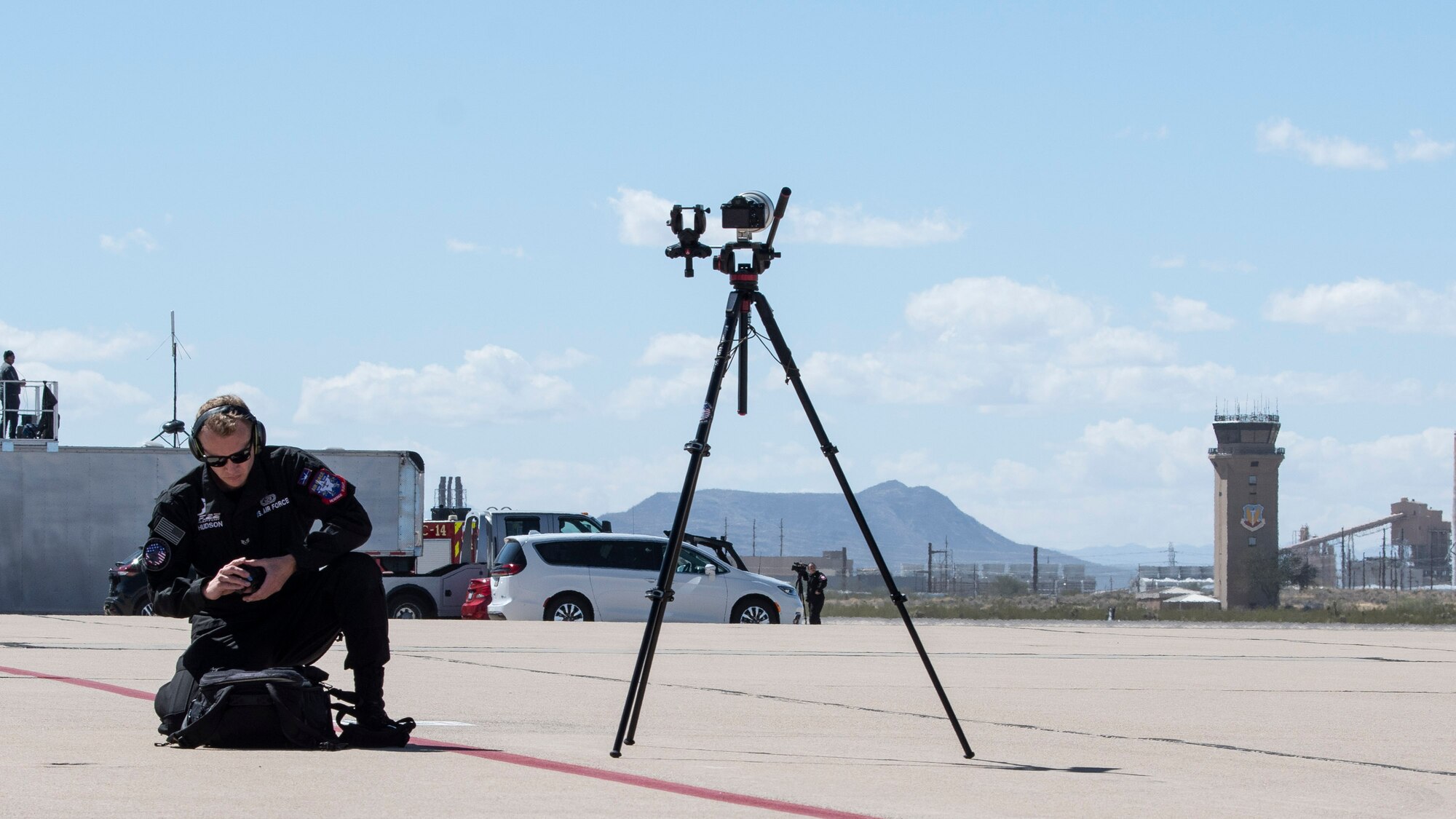 Man get camera gear ready on the flightline.