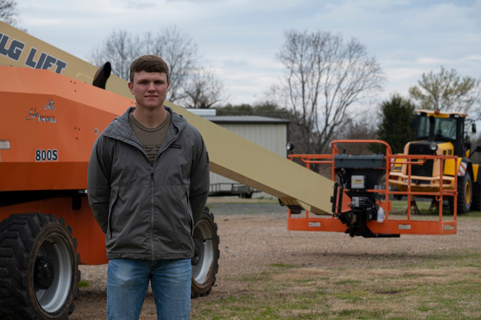 A man stands in front of construction equipment.