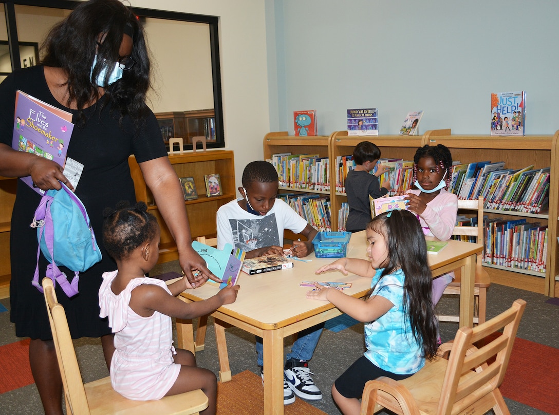 Keneesha Ricks, standing, points out a picture in a book to her daughter, Kaliyah, center, as her two other children, clockwise from left, Timothy Tillman and Jordan Ricks, enjoy some activities in the children’s room March 9 at the new Fort Irwin Library. Also pictured is Ella Camarena, seated right. The U.S. Army Corps of Engineers Los Angeles District’s Fort Irwin Resident Office managed the construction of the facility.