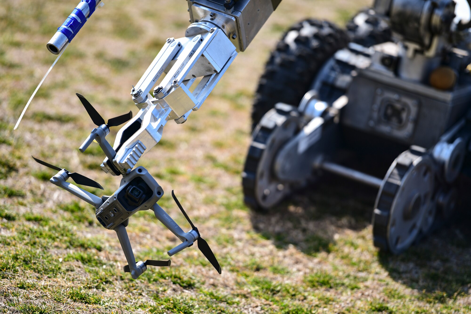 A robot picks up a small unmanned aircraft system.