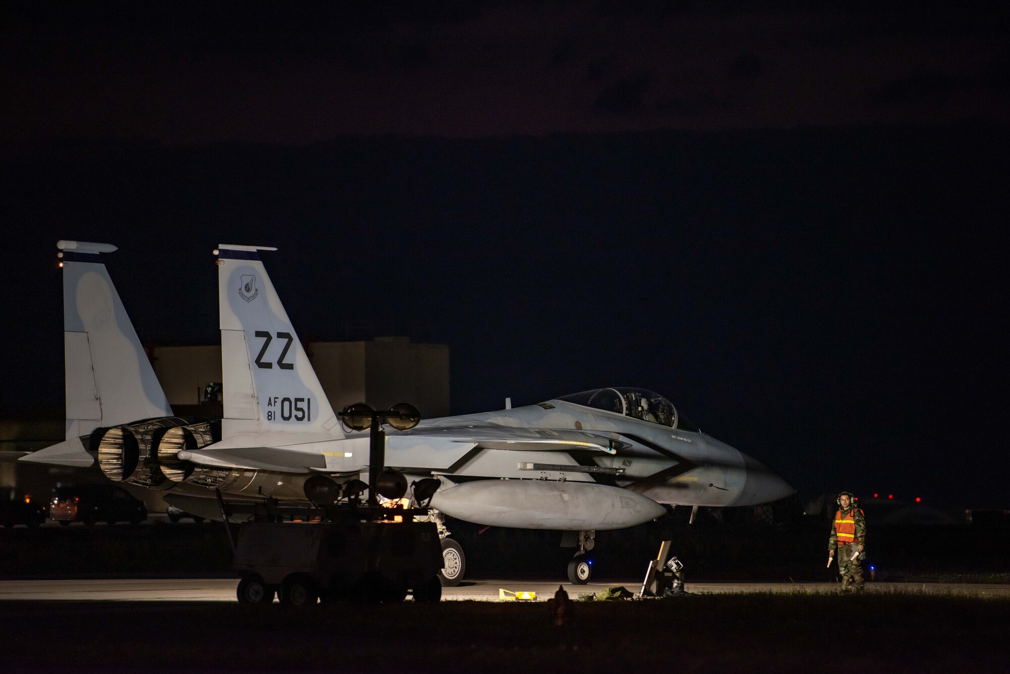 An F-15C Eagle taxi's on a flightline before takeoff at sunset.