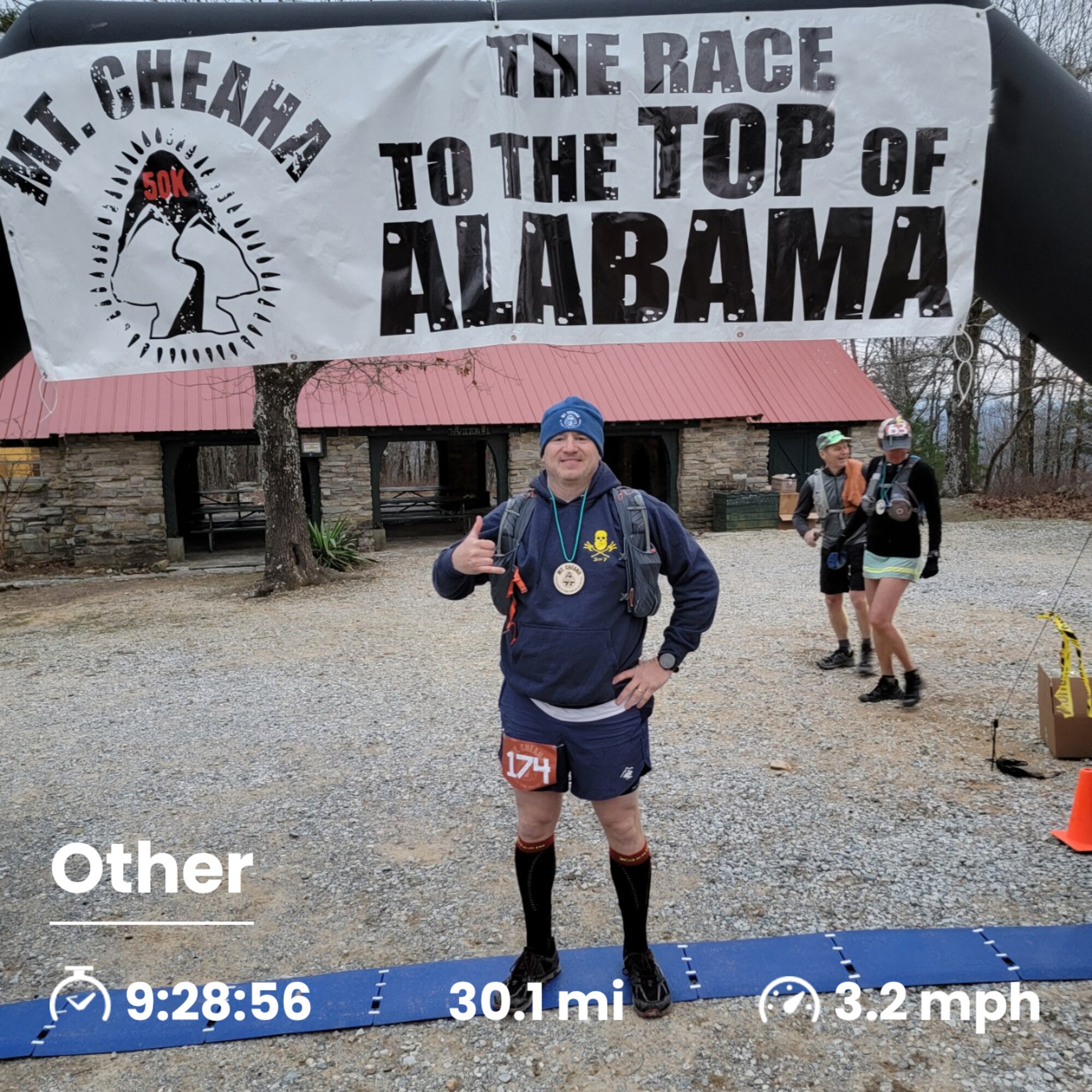 Lt. Col. Weed stands in running gear at a finish line. Banner above reads "Mt. Cheaha The Race to the Top of Alabama"