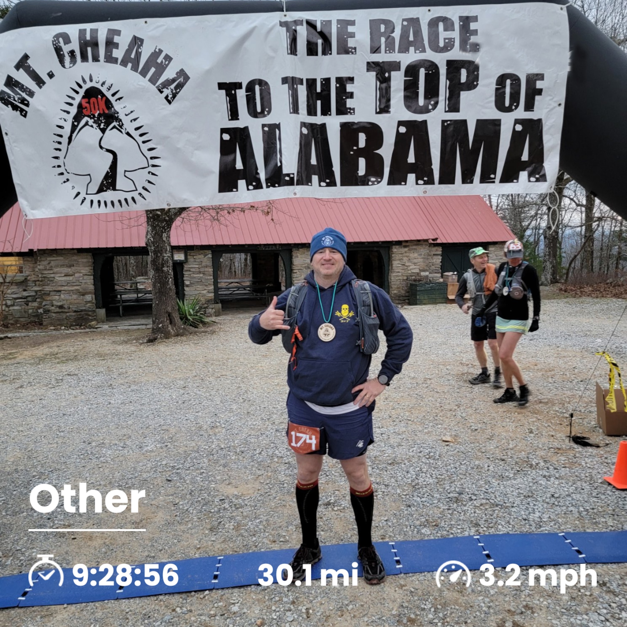 Lt. Col. Weed stands in running gear at a finish line. Banner above reads "Mt. Cheaha The Race to the Top of Alabama"