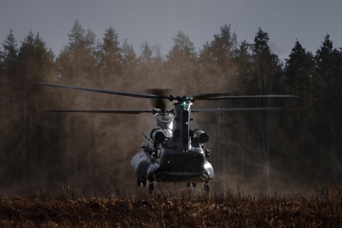 A helicopter hovers over the ground.