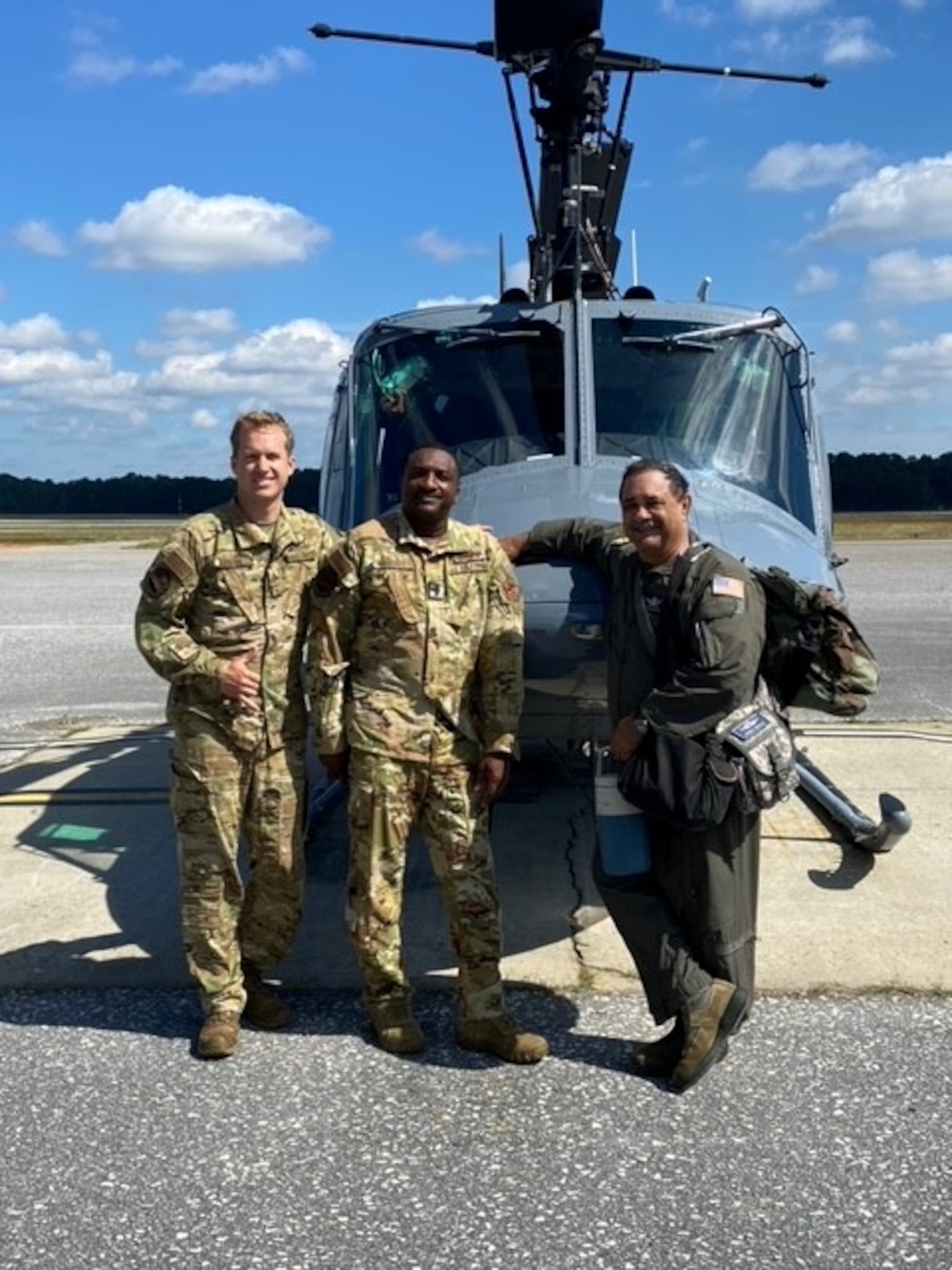 Two military helicopter pilot students pose with an instructor in front of a training helicopter at Ft. Rucker, Ala.