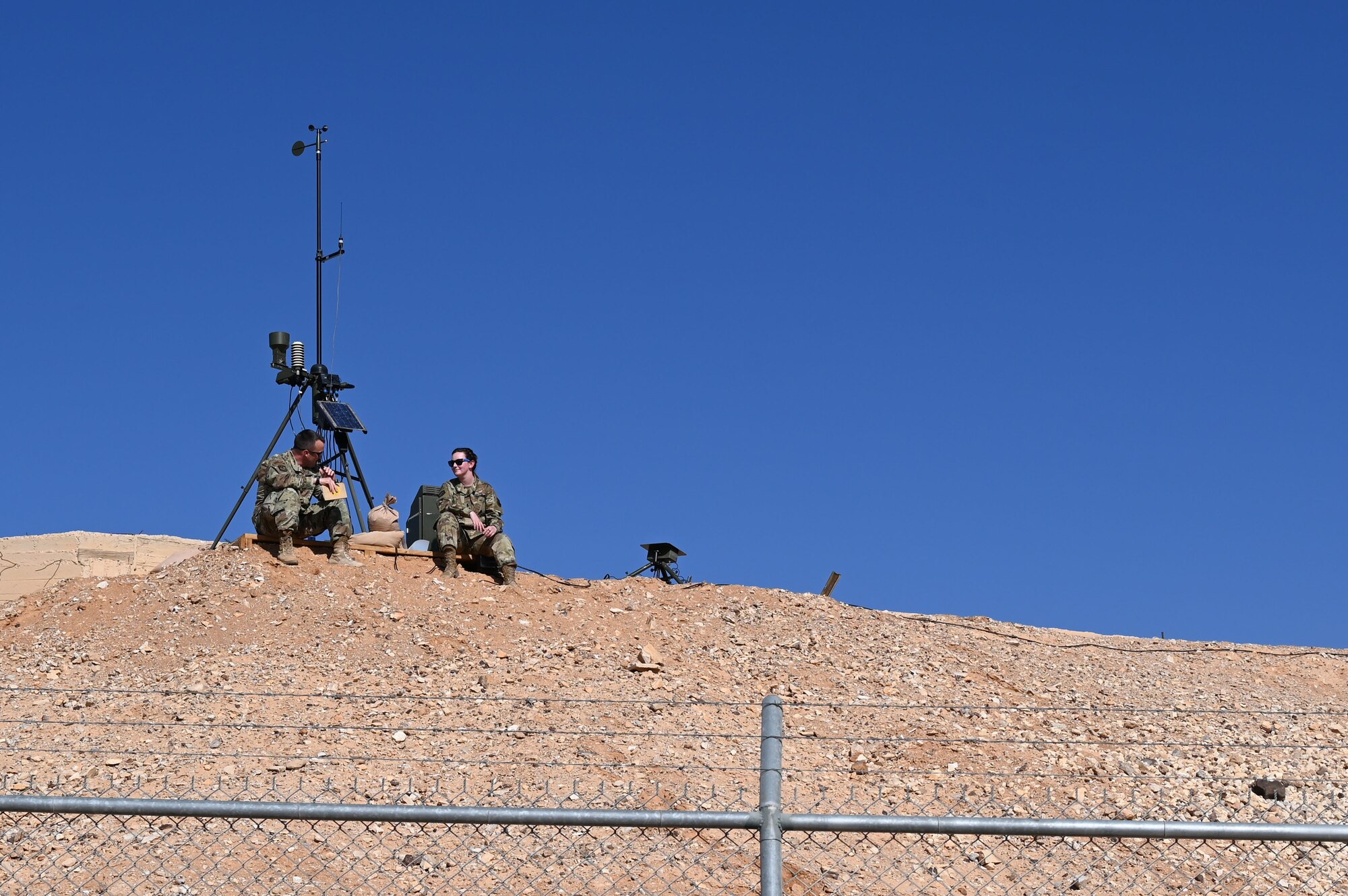 U.S. Air Force Lt. Col. Prichard "Mule" Keely, 332d Expeditionary Operations Support Squadron commander, with 1st Lt. Judith Swan, 332d EOSS Weather Flight officer in charge, sit with the TMQ-53, a portable automated weather station at an undisclosed location in Southwest Asia, Jan. 11, 2022. The 332d EOSS Weather Flight delivers customized meteorological support for the 332d Air Expeditionary Wing's varied structural and agency sensitivities.
(U.S. Air Force photo by Tech. Sgt. Lauren M. Snyder)