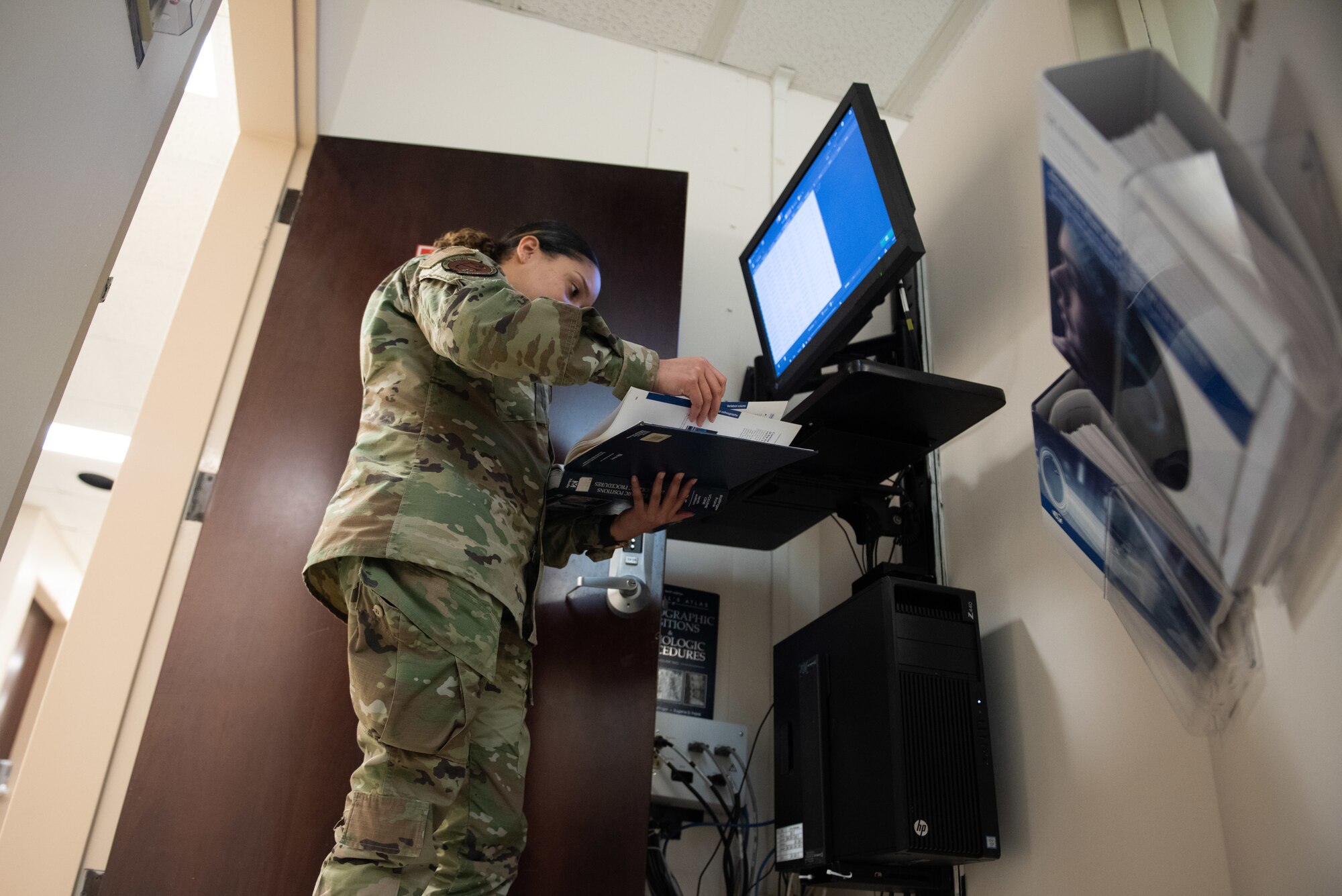 Staff Sgt. Gloria Garcia, an ultrasound technician assigned to the 39th Medical Group, references a radiology textbook while analyzing diagnostic images at Incirlik Air Base, Turkey, March 14, 2022. Radiology uses X-rays to photograph human anatomy to assist doctors in identifying potential disease and injury to continue caring for patients. (U.S. Air Force photo by Airman 1st Class Brandt Self)