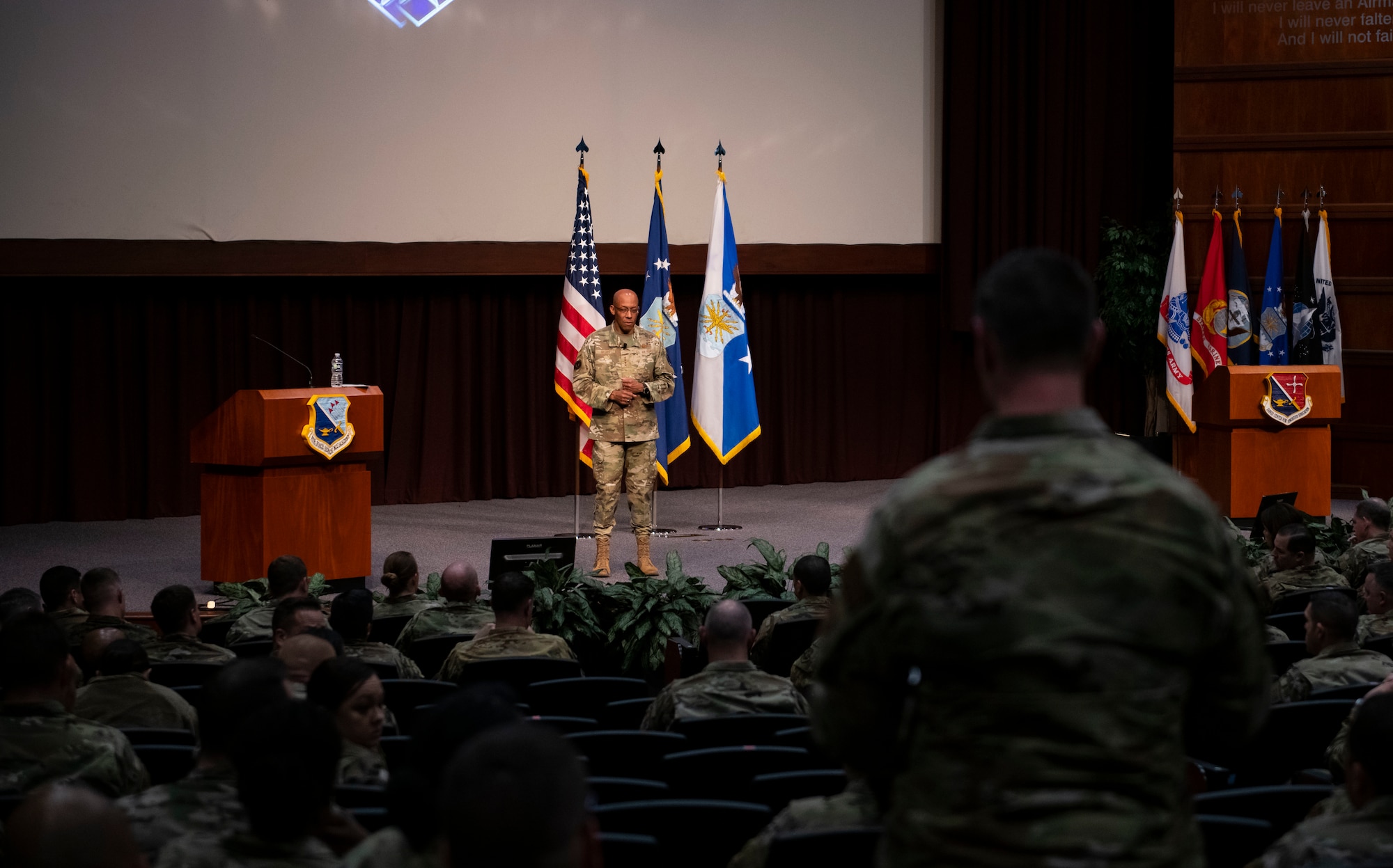 Air Force Chief of Staff Gen. CQ Brown, Jr. speaks on stage at the Air Force Senior Noncommissioned Officer Academy, March 10, 2022, while a student stands to ask a question, joined by many of the Airman's peers.
