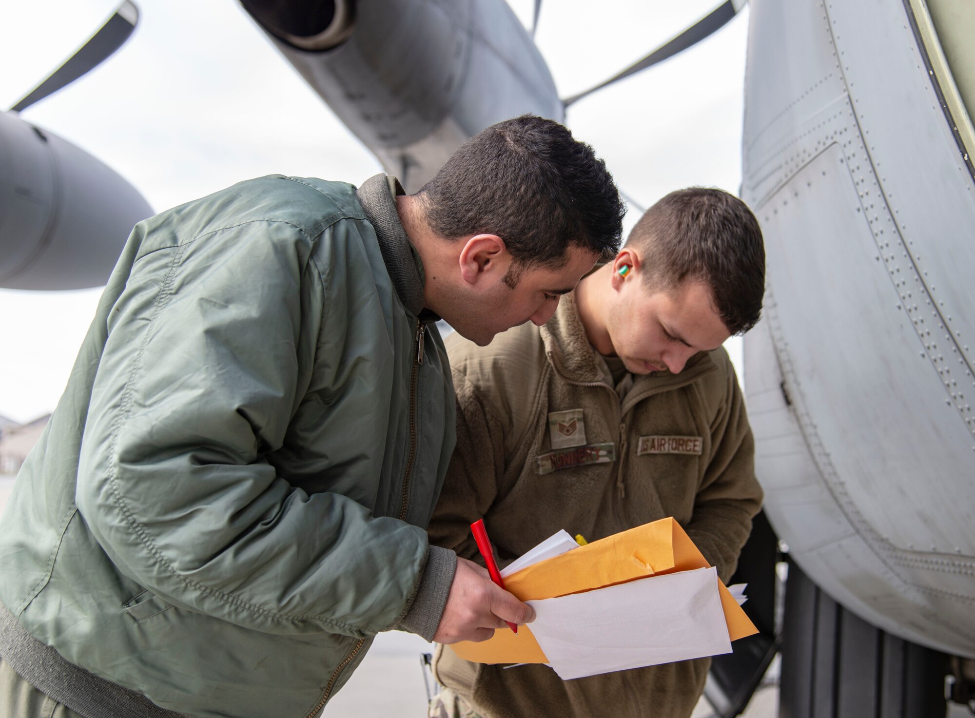 Staff Sgt. Austin Nunnery, 436th Aerial Port Squadron ramp controller, reviews foreign military sales cargo shipping documents with a Tunisian air force C-130J Super Hercules aircrew member at Dover Air Force Base, Delaware, March 10, 2022. The U.S. and Tunisia have enjoyed strong diplomatic relations for over 200 years, beginning when the two countries signed the Treaty of Peace and Friendship in 1797. Due to its strategic geographic location, Dover AFB supports approximately $3.5 billion worth of FMS operations annually. (U.S. Air Force photo by Roland Balik)