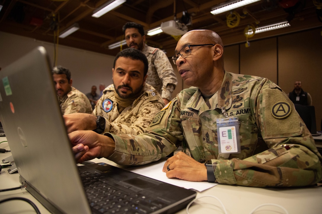 U.S. Army Sgt. Major Marcus Carter, assigned to U.S. Army Central (ARCENT), right, and Capt. Mohamed Alsebaiei, a Royal Bahraini Air Force officer, left, collaborate on a situational update brief during scenario exercise Eagle Resolve 22, at Fort Carson, Colorado, March 12, 2022. The exercise offers participants an opportunity to develop interoperability between partner nations in the realm of civilian population and infrastructure defense. (U.S. Army photo by Spc. Robert Vicens)