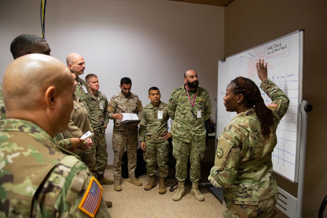 U.S. Army Major Rayvon Stanley, a medical planner with U.S. Army Central (ARCENT), right, provides a medical analysis brief to a Combined Joint Sustainment Team (CJST) consisting of U.S. and Gulf Cooperation Council (GCC) counterparts, during Eagle Resolve 22, at Fort Carson, Colorado, March 12, 2022. The team identifies hospitals in each partner country, and procedures for medical evacuation of civilian and military during the scenario driven event. Eagle Resolve 22 is focused on a unified vision between partner nations that protects civilian populations and infrastructure from air and missile threats. (U.S. Army photo by Spc. Robert Vicens)