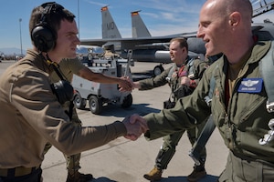U.S. Air Force crew chiefs from the 389th Fighter Generation Squadron shake hands with F-15E Strike Eagle pilots.